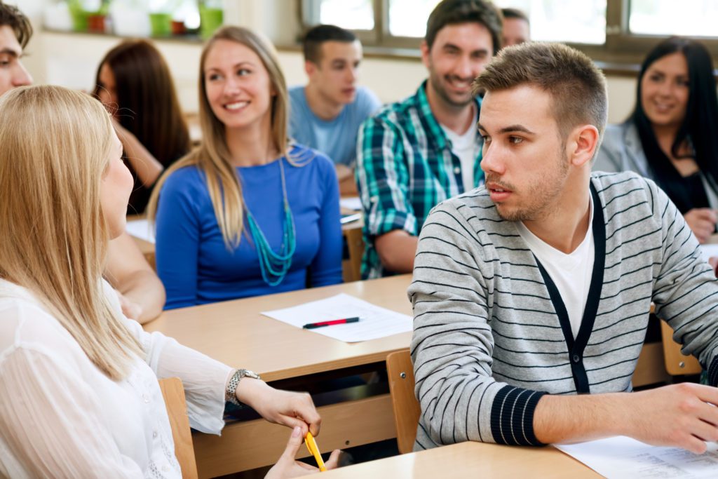 College students talking during class in a classroom