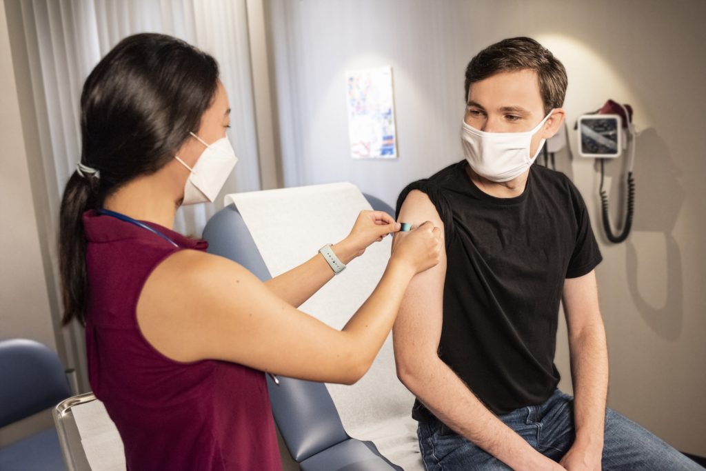 Nurse putting a bandaid on patient.