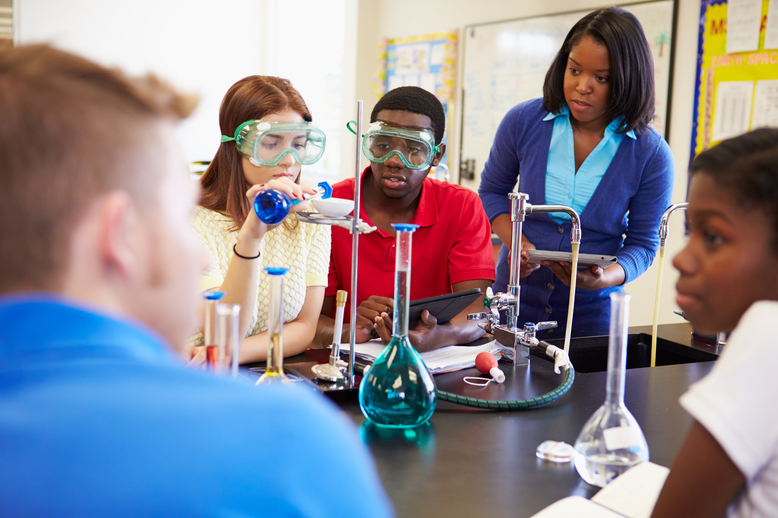female teacher in chemistry lab with students