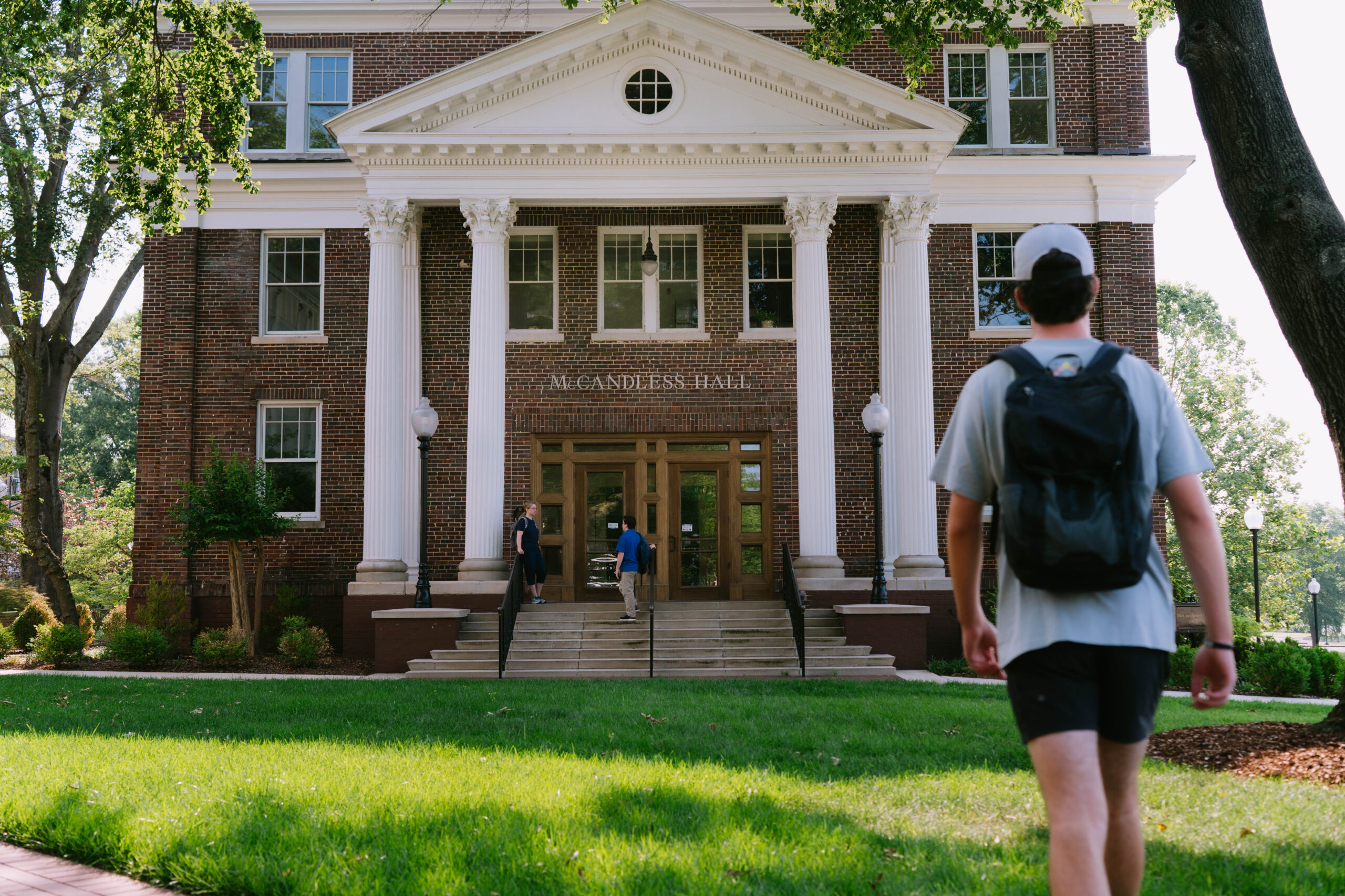 Student walks across campus to a building