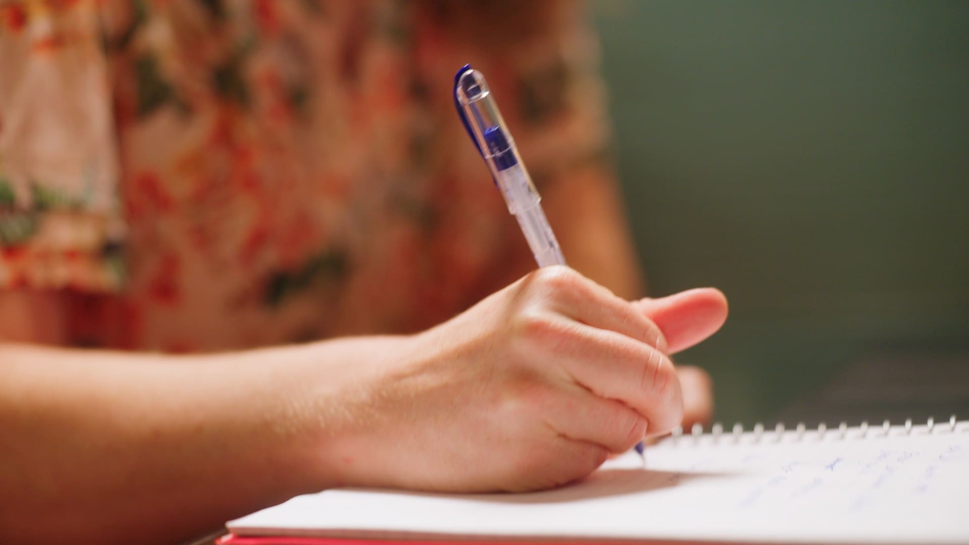 Close-up of hand writing in a notebook
