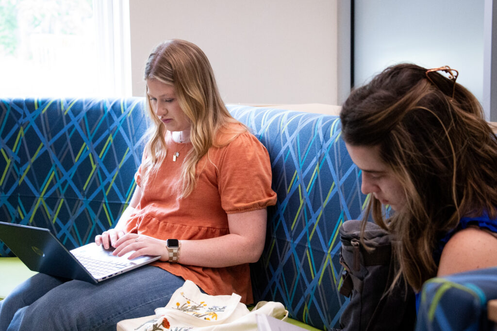 Students studying on laptop in classroom close-up