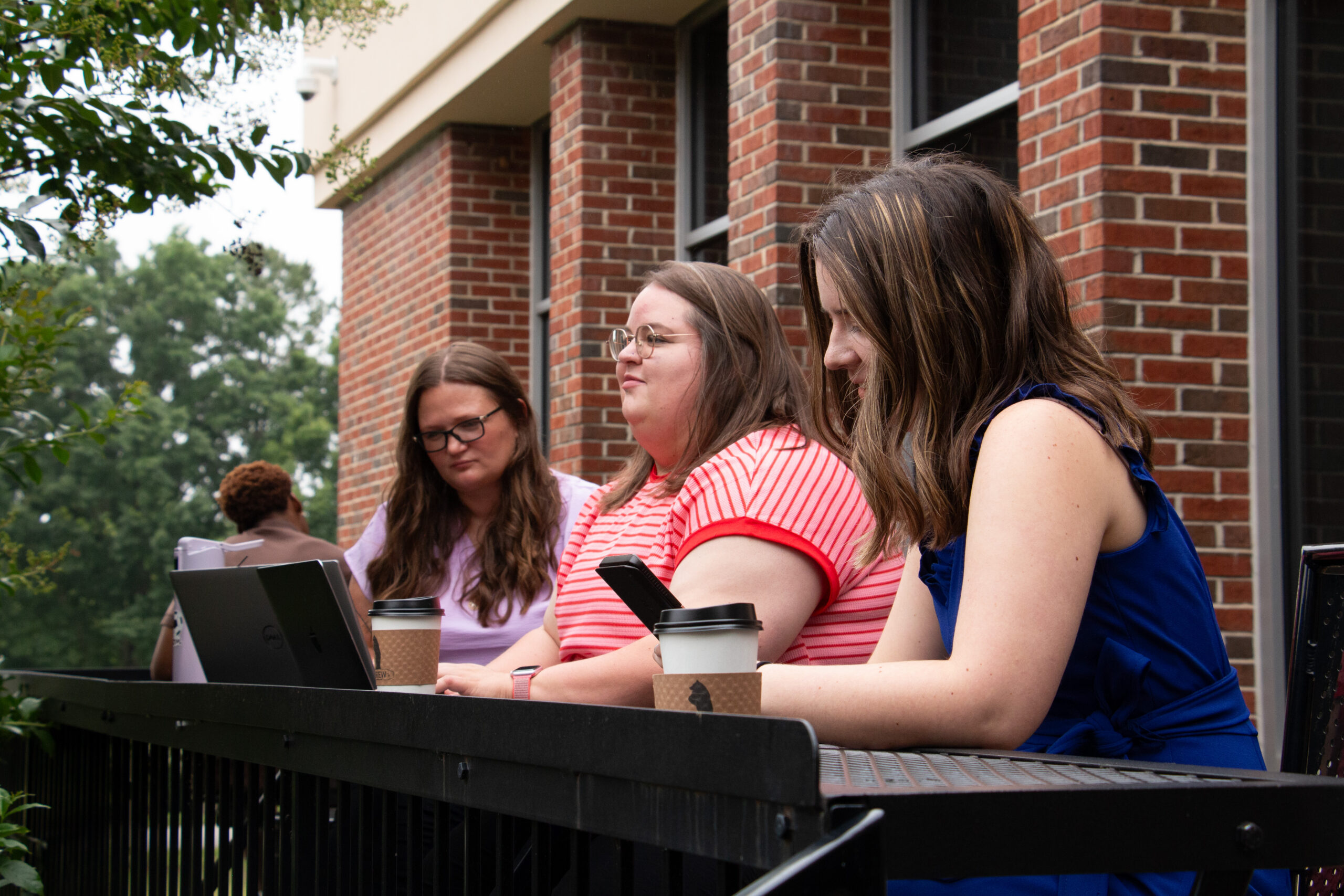 students outdoor with computer and table